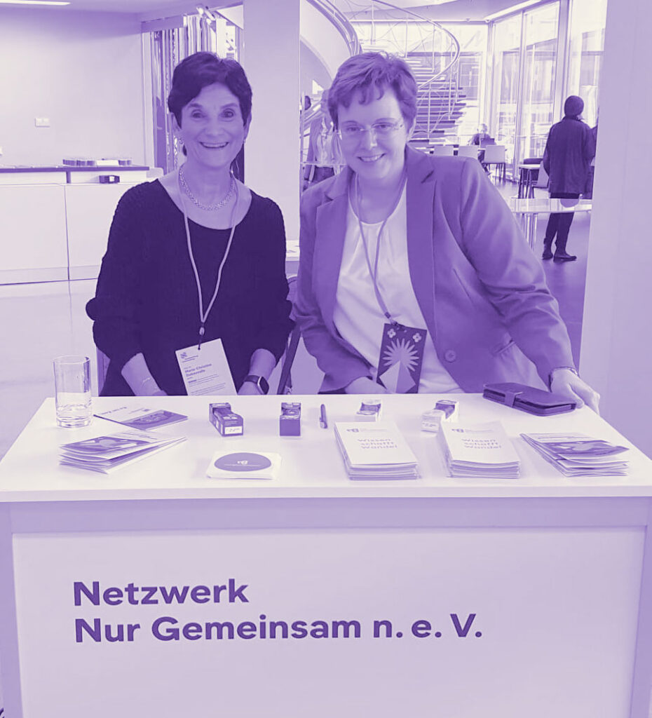 Zwei Frauen des Netzwerks ‚Nur Gemeinsam‘ am Infostand mit Infomaterial.